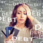 A distressed woman holds credit cards, representing the burdens of dealing with debt collectors in WV.