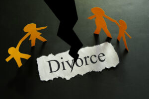 Image of the word divorce being divided, along with a paper doll family, representing filing for divorce in WV with the guidance of Jason Harwood, a southern WV divorce attorney.