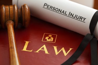 Image of a scroll labeled "personal injury" by a gavel labeled "lawyer," representing how a Logan, WV personal injury lawyer is most qualified to handle local claims and cases.