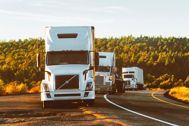 Image of semi-trucks on the side of a small road, representing the need for Logan County truck accident lawyer Jason Harwood when someone is injured or killed in an accident with a large truck in southern WV.