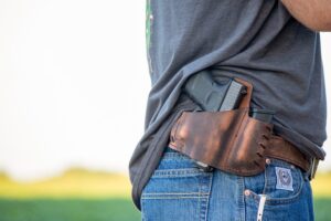 A man with a gun in a holster, representing the benefits of a West Virginia concealed carry permit out-of-state.
